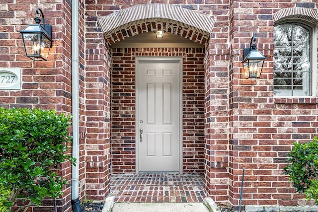 doorway to property featuring brick siding