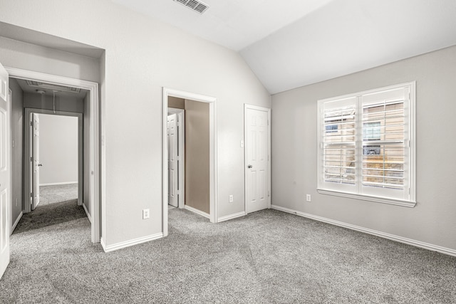 unfurnished bedroom with carpet floors, visible vents, baseboards, attic access, and vaulted ceiling