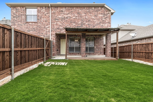 rear view of house featuring a lawn, a fenced backyard, a patio area, and brick siding