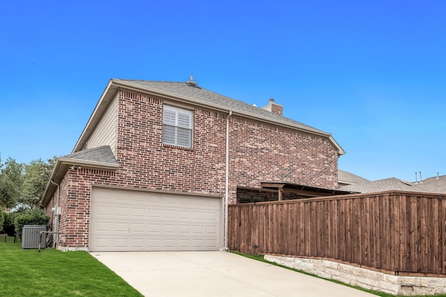 view of home's exterior featuring a chimney, roof with shingles, brick siding, fence, and concrete driveway