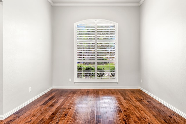empty room featuring baseboards, ornamental molding, and hardwood / wood-style floors