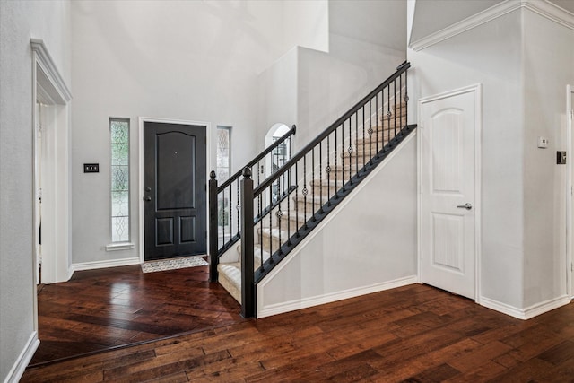 entrance foyer with baseboards, a high ceiling, and hardwood / wood-style flooring