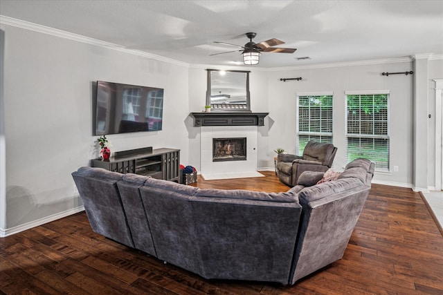 living area featuring ceiling fan, a fireplace with flush hearth, ornamental molding, and hardwood / wood-style floors