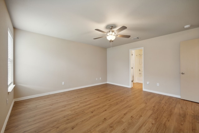 empty room featuring baseboards, a ceiling fan, light wood-style flooring, and a healthy amount of sunlight