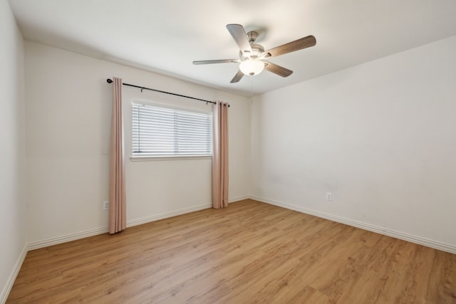 empty room featuring a ceiling fan, baseboards, and light wood-style floors