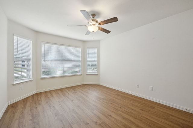 spare room featuring a ceiling fan, baseboards, and wood finished floors