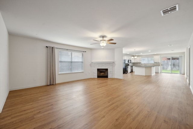 unfurnished living room featuring baseboards, ceiling fan, light wood-style flooring, and visible vents