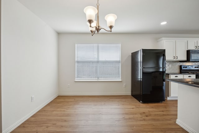 kitchen featuring an inviting chandelier, white cabinetry, black appliances, and dark countertops