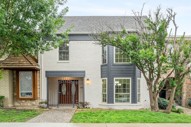view of front of property featuring brick siding and a front lawn