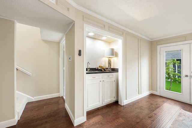 bar with crown molding, wet bar, dark wood finished floors, and a sink