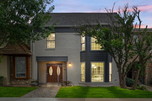 view of front of house featuring brick siding and a front yard