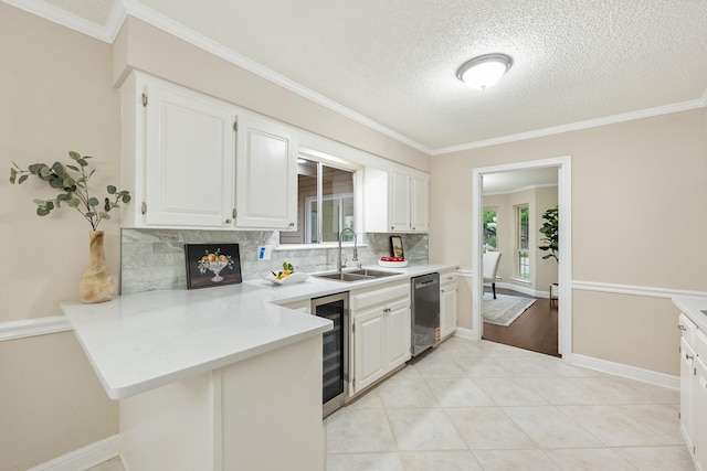 kitchen with backsplash, stainless steel dishwasher, a sink, a peninsula, and beverage cooler