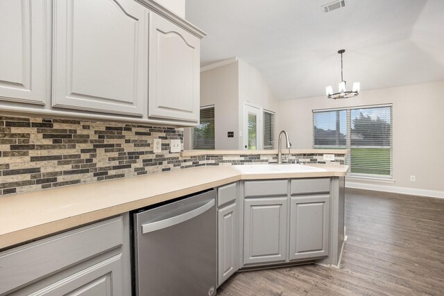 kitchen with a sink, a peninsula, tasteful backsplash, stainless steel dishwasher, and visible vents