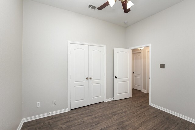 unfurnished bedroom with baseboards, dark wood-style flooring, and visible vents