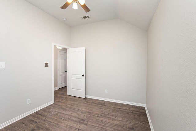 empty room with ceiling fan, visible vents, vaulted ceiling, wood finished floors, and baseboards