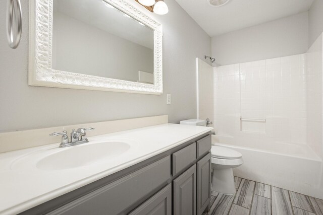 bathroom with shower / bathtub combination, toilet, and vanity