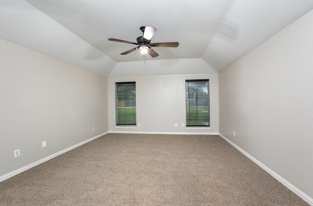 unfurnished room featuring a ceiling fan, baseboards, lofted ceiling, and carpet