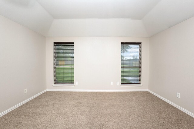 unfurnished room featuring baseboards, carpet, and vaulted ceiling