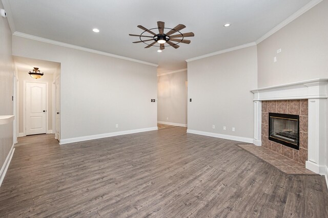 unfurnished living room with ceiling fan, ornamental molding, wood finished floors, and a tile fireplace
