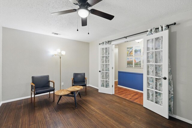 sitting room with baseboards, a textured ceiling, ceiling fan, and wood finished floors