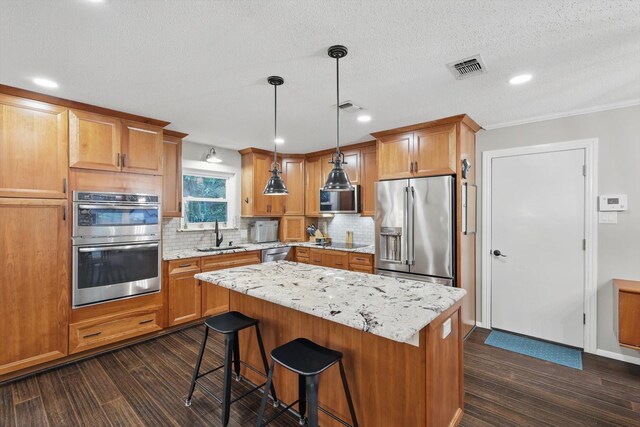 kitchen with visible vents, decorative backsplash, dark wood-style flooring, and stainless steel appliances