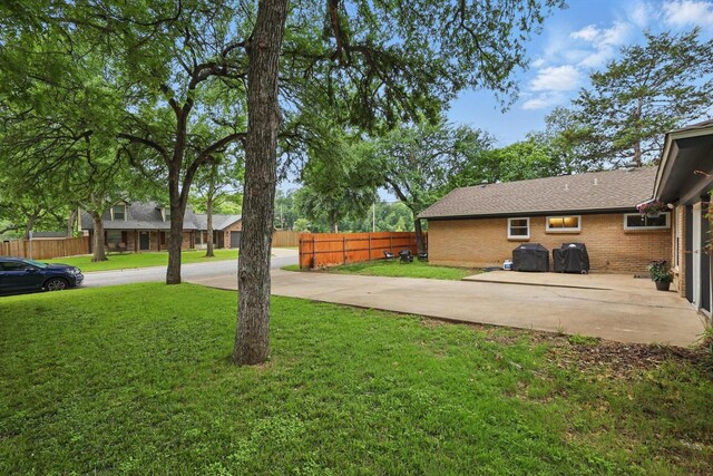 view of yard featuring fence and a patio