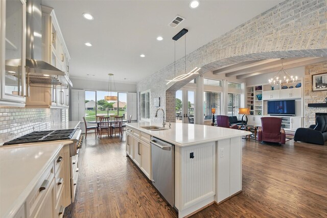 kitchen with wall chimney range hood, a sink, stainless steel appliances, dark wood-type flooring, and visible vents