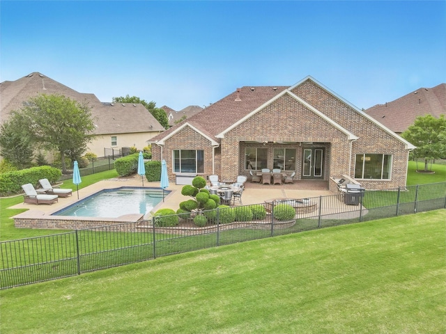 back of house with a yard, brick siding, a fenced backyard, and a patio area
