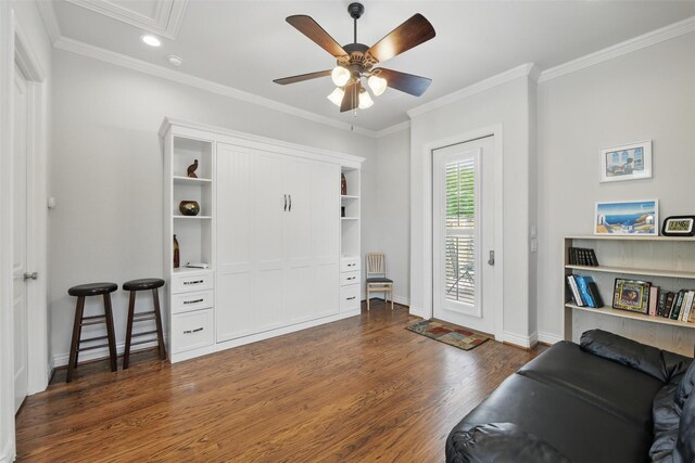 living area with ceiling fan, attic access, baseboards, ornamental molding, and dark wood-type flooring