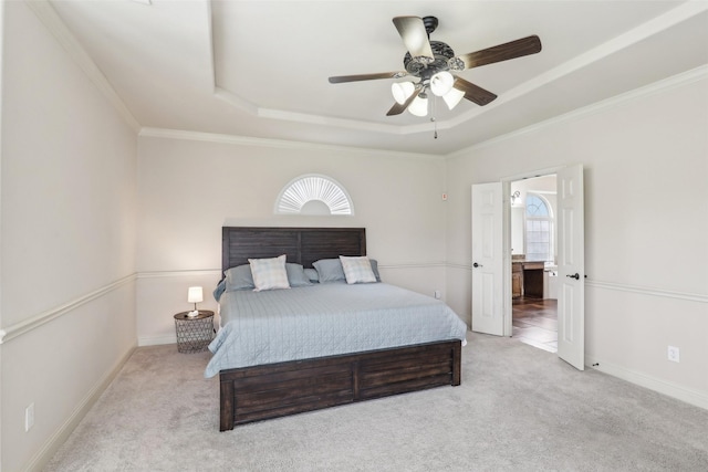 carpeted bedroom with baseboards, a ceiling fan, a raised ceiling, and ornamental molding