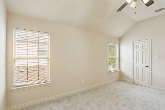 carpeted spare room with baseboards, a ceiling fan, lofted ceiling, and visible vents