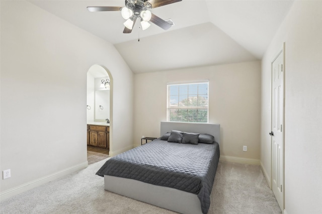 bedroom featuring a sink, baseboards, lofted ceiling, and light colored carpet