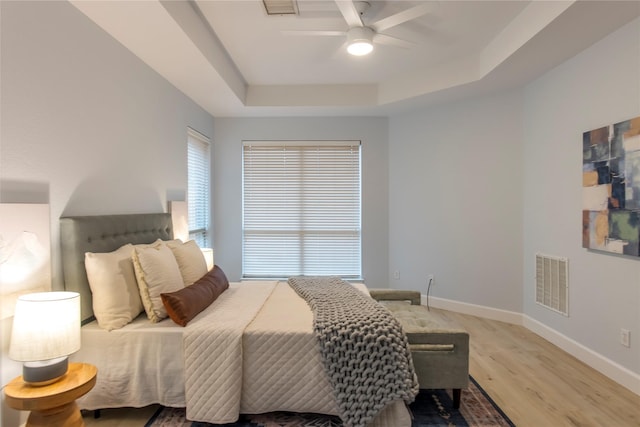 3501 Washington Dr, Frisco, TX 75034 - bedroom featuring light wood-style floors, baseboards, a tray ceiling, and ceiling fan