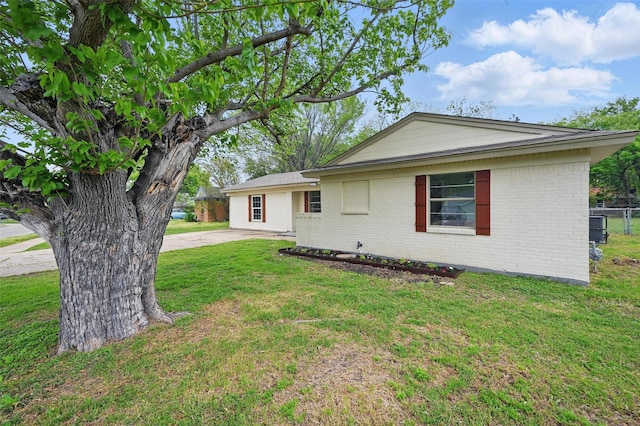 single story home featuring a front lawn and brick siding