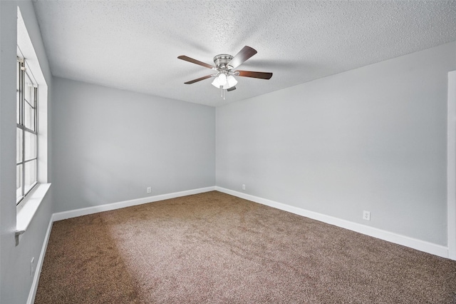 carpeted spare room with baseboards, ceiling fan, and a textured ceiling