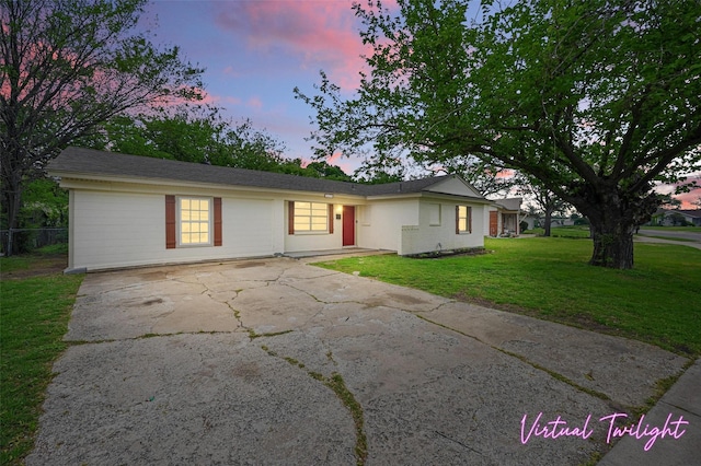 ranch-style home with driveway and a front lawn