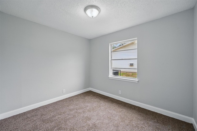 unfurnished room with baseboards, dark carpet, and a textured ceiling