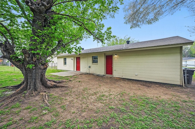 rear view of property with brick siding, fence, and a patio area