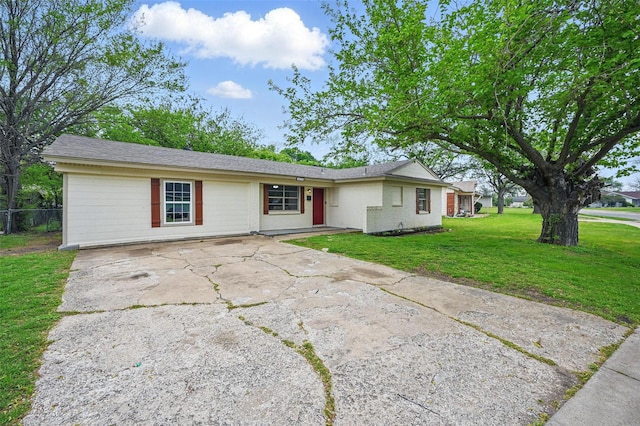 ranch-style home featuring fence, driveway, and a front lawn
