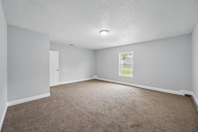 spare room with baseboards, carpet flooring, and a textured ceiling
