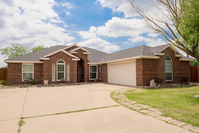 single story home featuring fence, brick siding, a garage, a front yard, and driveway
