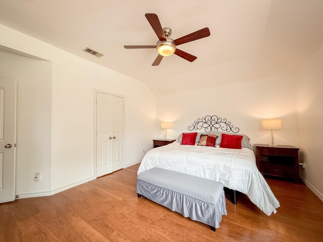 bedroom featuring visible vents, baseboards, wood finished floors, and vaulted ceiling