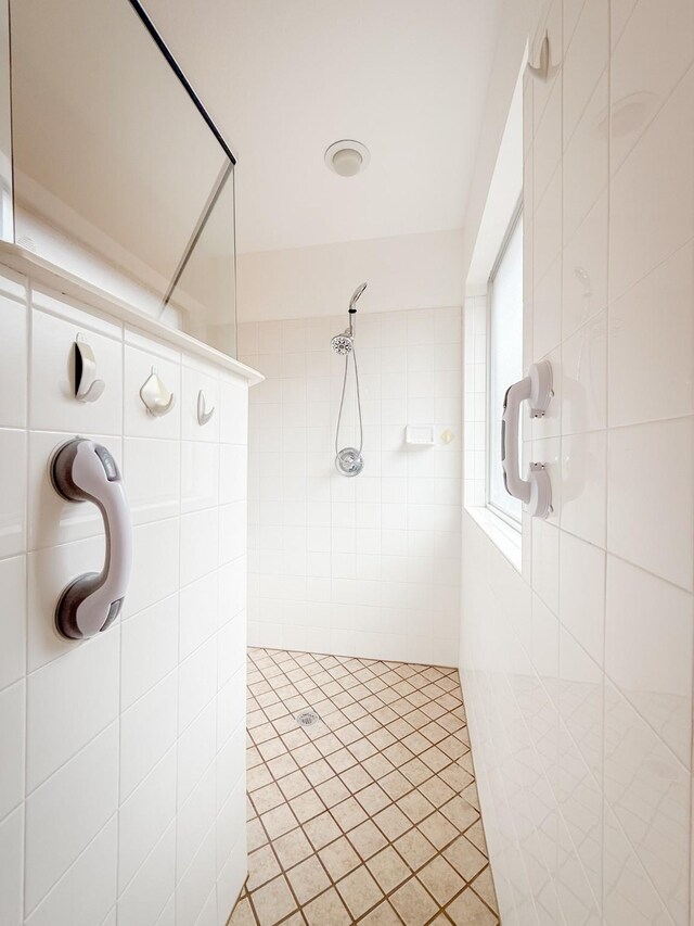 bathroom featuring tile walls and tiled shower