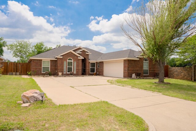 single story home with brick siding, a garage, a shingled roof, and concrete driveway