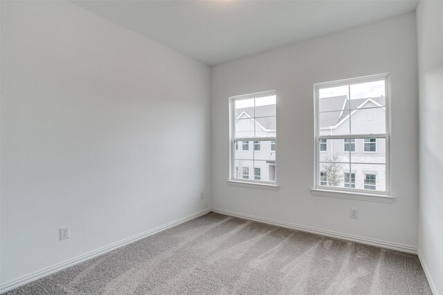 carpeted spare room with baseboards