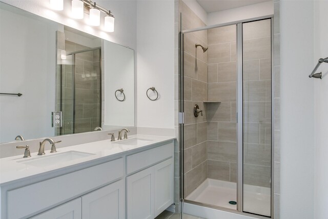 full bathroom featuring double vanity, a sink, and a stall shower