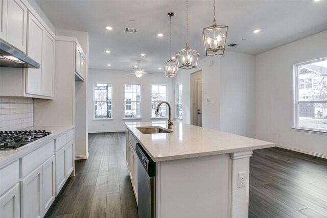 kitchen with a healthy amount of sunlight, visible vents, a sink, ceiling fan with notable chandelier, and stainless steel appliances