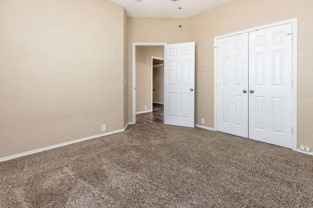 unfurnished bedroom with carpet floors, baseboards, and a closet