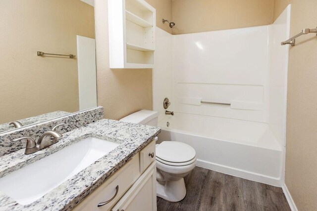 full bath with shower / bathtub combination, toilet, wood finished floors, and vanity