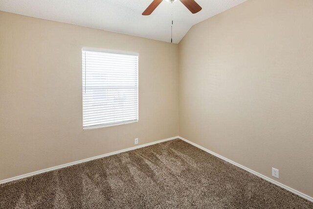 carpeted spare room featuring baseboards, a ceiling fan, and vaulted ceiling